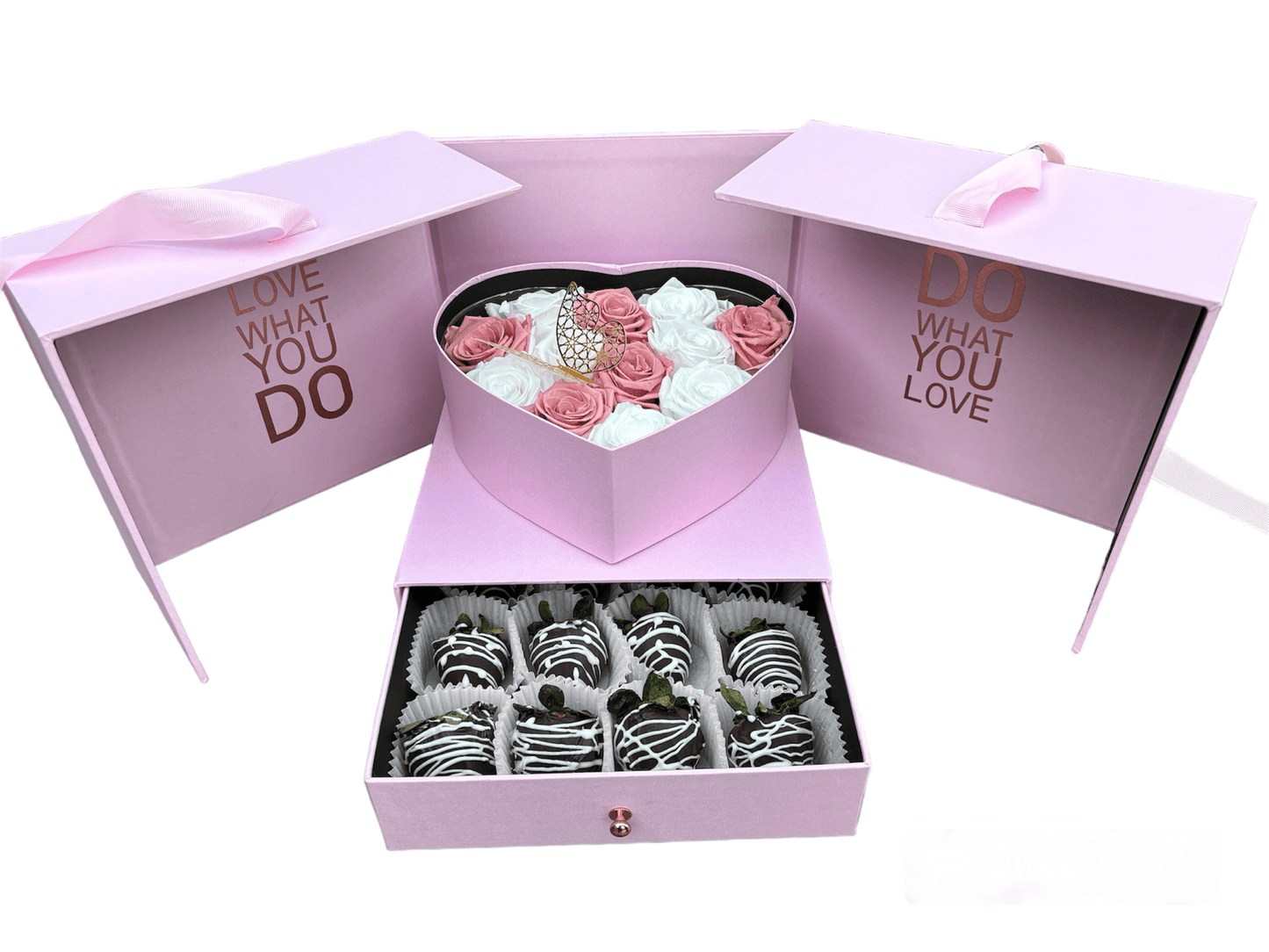 Pink gift box with heart-shaped lid containing flowers and a smaller box with chocolate-covered treats.