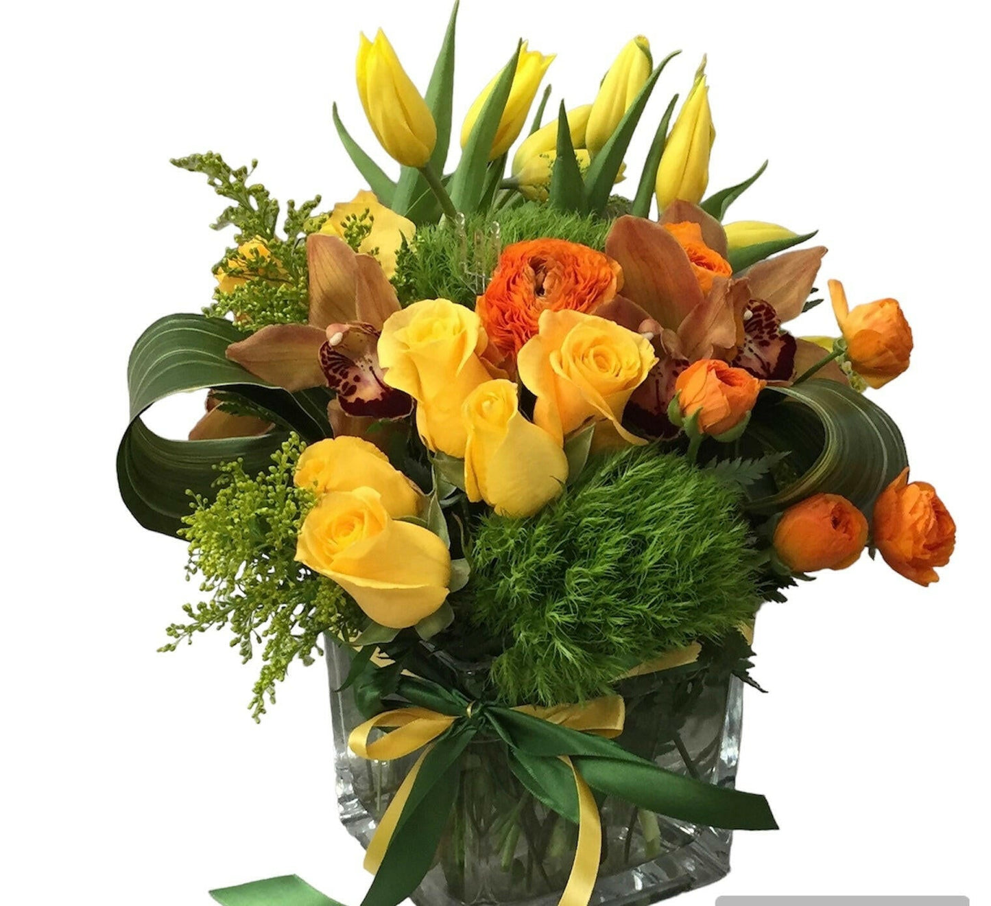 Bouquet of yellow and orange flowers with greenery in a clear vase on a white background