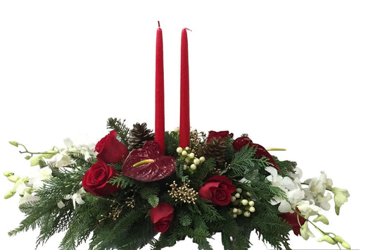 Decorative floral arrangement with red candles, greenery, and flowers for christmass on a white background