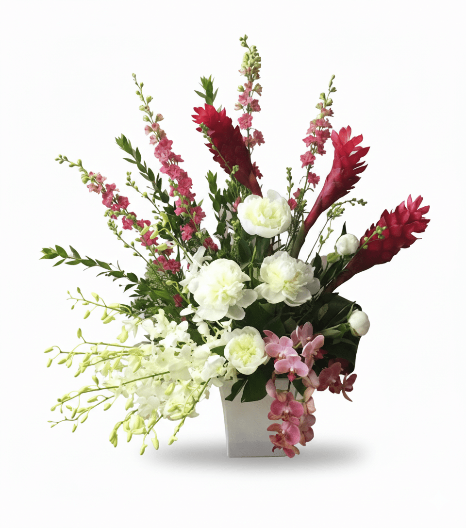 A tall, elegant floral arrangement in a white vase, featuring white peonies, red ginger, red and pink snapdragons, and white and pink orchids.
