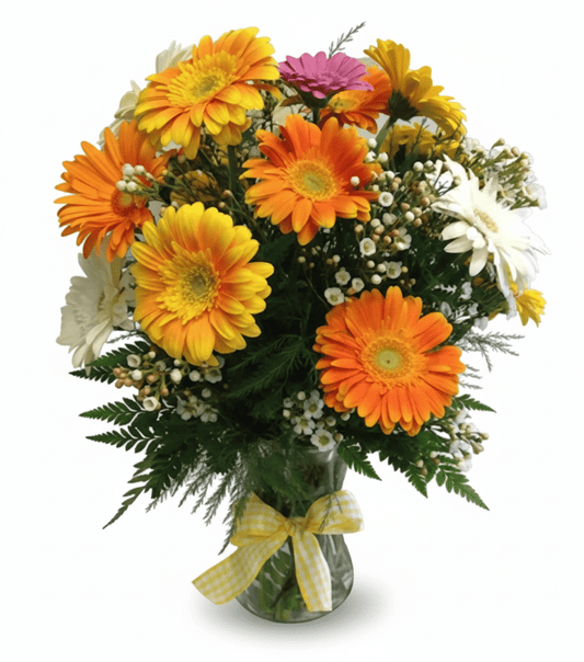 A vibrant bouquet of orange, yellow, pink, and white gerbera daisies, accented with baby's breath and green foliage, in a clear glass vase tied with a yellow gingham ribbon.