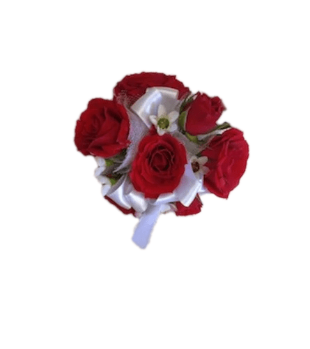 Wrist corsage of mini red roses with small white filler flowers, greenery, and a white satin ribbon, shown on an ivory background.