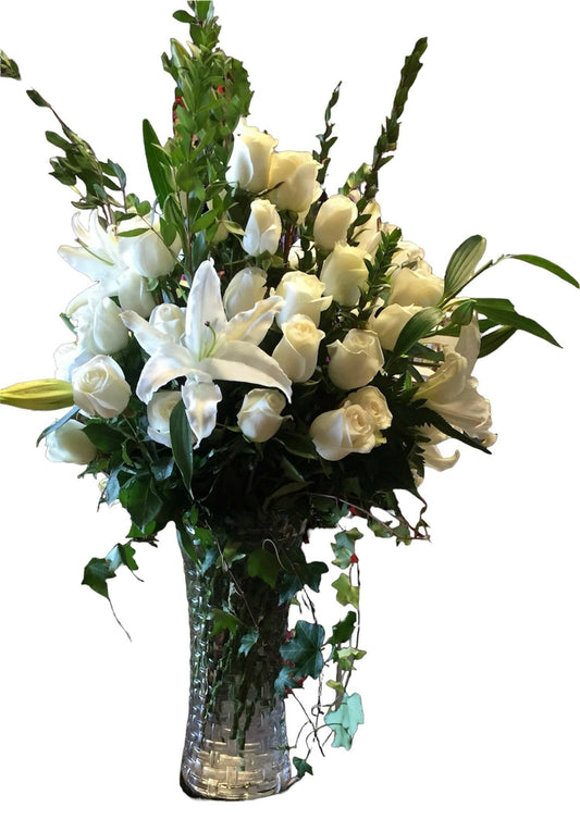Bouquet of white flowers in a clear vase on a white background