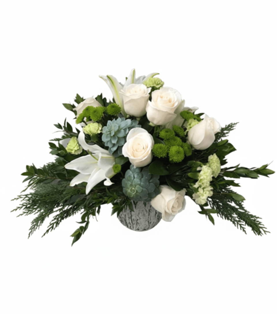 elegant, low-profile floral arrangement named "Snowflake Arrangement" in a textured white vase, set against a solid white background. It features pristine white roses and white oriental lilies, accented with clusters of vibrant green button chrysanthemums, blue-green succulents, and various deep green foliages including feathery cedar.