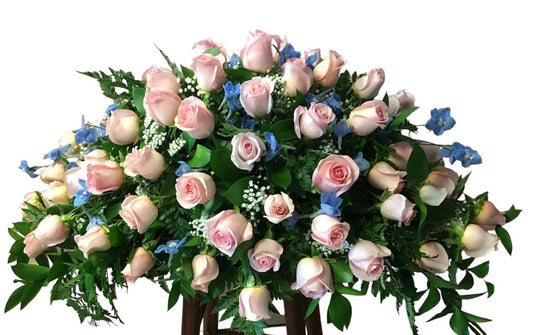 Cascade bouquet of pink and blue flowers with greenery on a white background