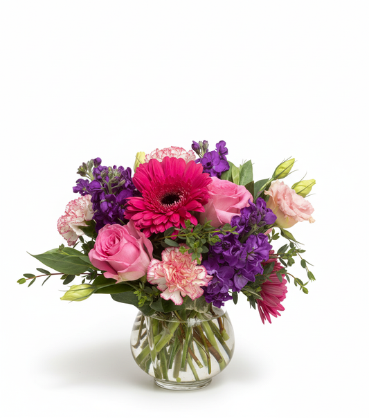 Bouquet of colorful flowers in a clear vase on a white background