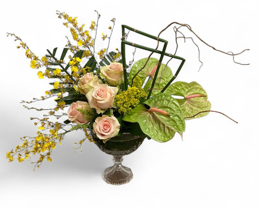Floral arrangement with roses and yellow flowers in a decorative container 