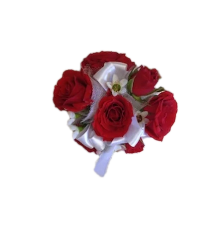 Wrist corsage of mini red roses with small white filler flowers, greenery, and a white satin ribbon, shown on an ivory background.