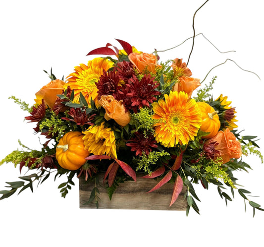 Autumn-themed floral arrangement with pumpkins on a white background