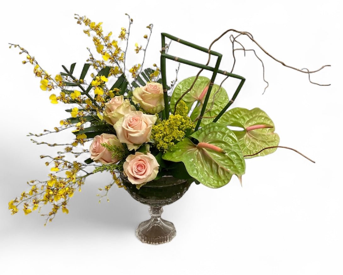 Floral arrangement with roses and yellow flowers in a decorative container 