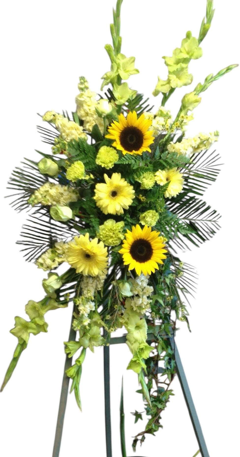 Floral arrangement with sunflowers and greenery on a stand against a white background