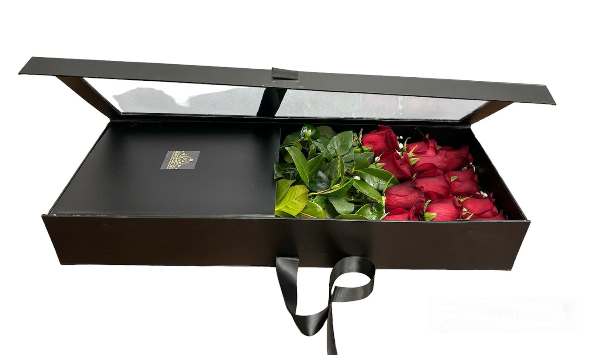 Black gift box with red roses and green leaves on a white background