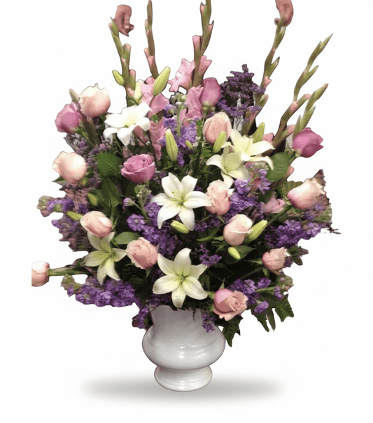Bouquet of flowers with pink, white, and purple flowers in a white vase on a white background