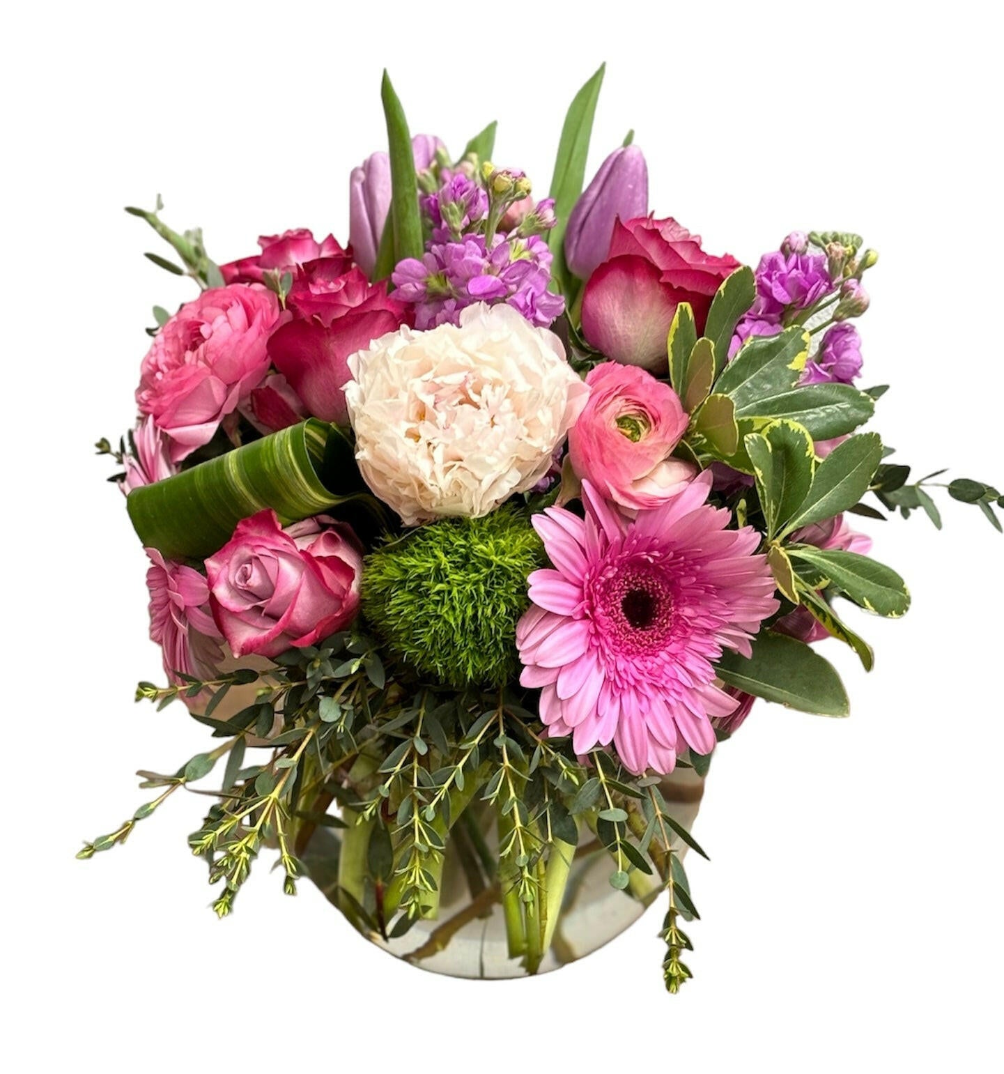 Bouquet of pink, green, and white flowers in a clear vase on a white background
