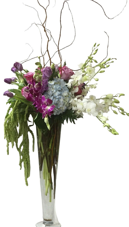 Wedding table floral arrangement in a clear vase on a white background