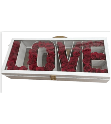 A white rectangular box with a clear lid, containing deep red roses meticulously arranged in separate compartments to spell out the word 'L-O-V-E', with a gold clasp on the front, against a white background.