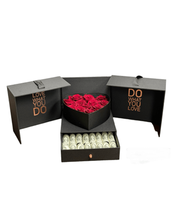 A luxurious black gift box that opens into three sections, with the phrases 'LOVE WHAT YOU DO' and 'DO WHAT YOU LOVE' in metallic text on the side panels. The center section has a top tier with a heart-shaped arrangement of red roses and a bottom drawer pulled out to reveal a fan of rolled-up dollar bills, all against a white background.