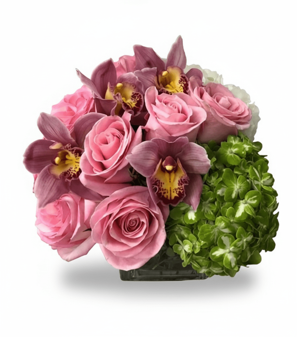 A compact floral arrangement in a square glass vase, featuring soft pink roses, fuchsia cymbidium orchids with yellow centers, and vibrant green hydrangea.