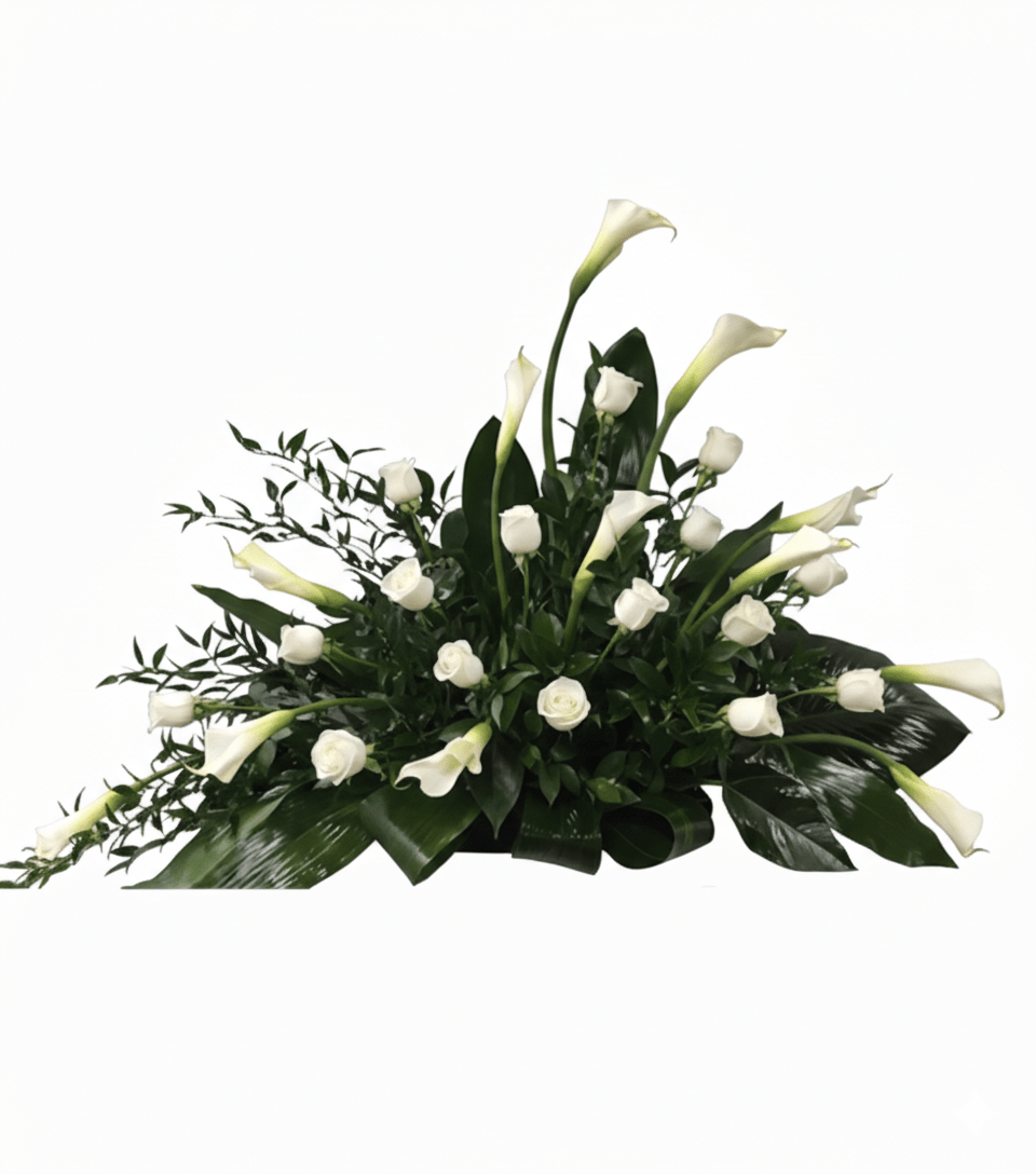 A complete and elegant horizontal floral arrangement named "Purity Of The Soul," featuring numerous white calla lilies and white roses interspersed with rich green foliage, including broad leaves and delicate leafy branches, all set against a solid white background.