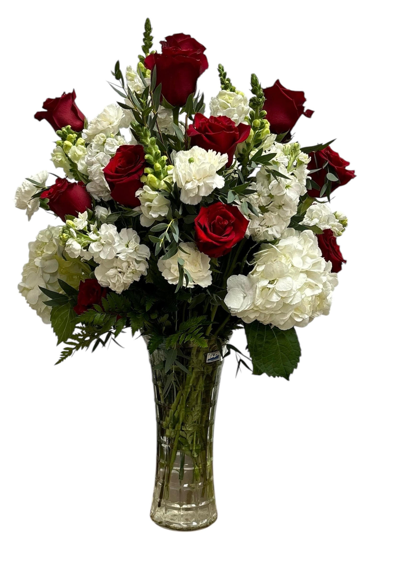 Bouquet of red and white flowers in a clear vase on a white background