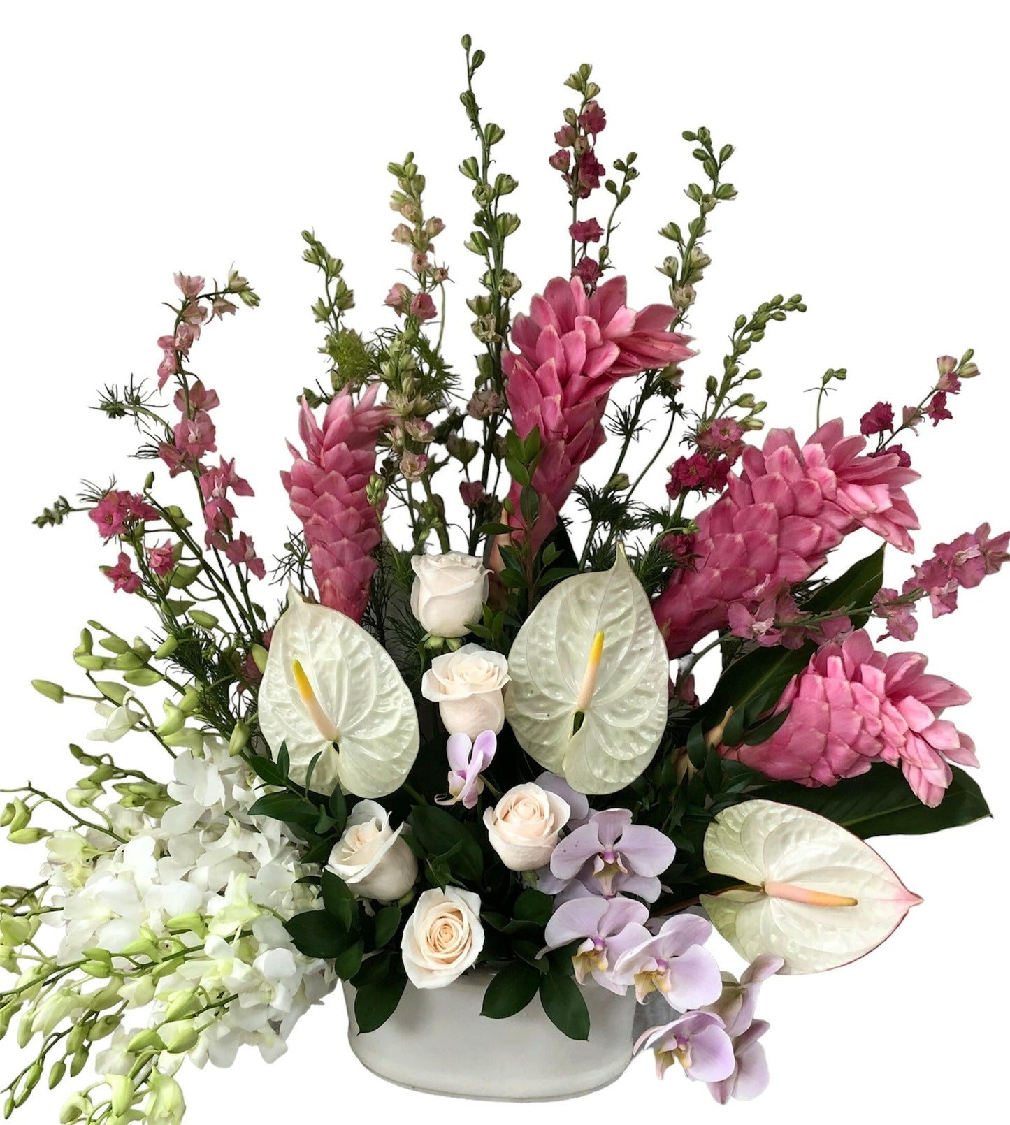 Colorful tropical flower arrangement with pink, white, and green flowers in a white vase on a white background