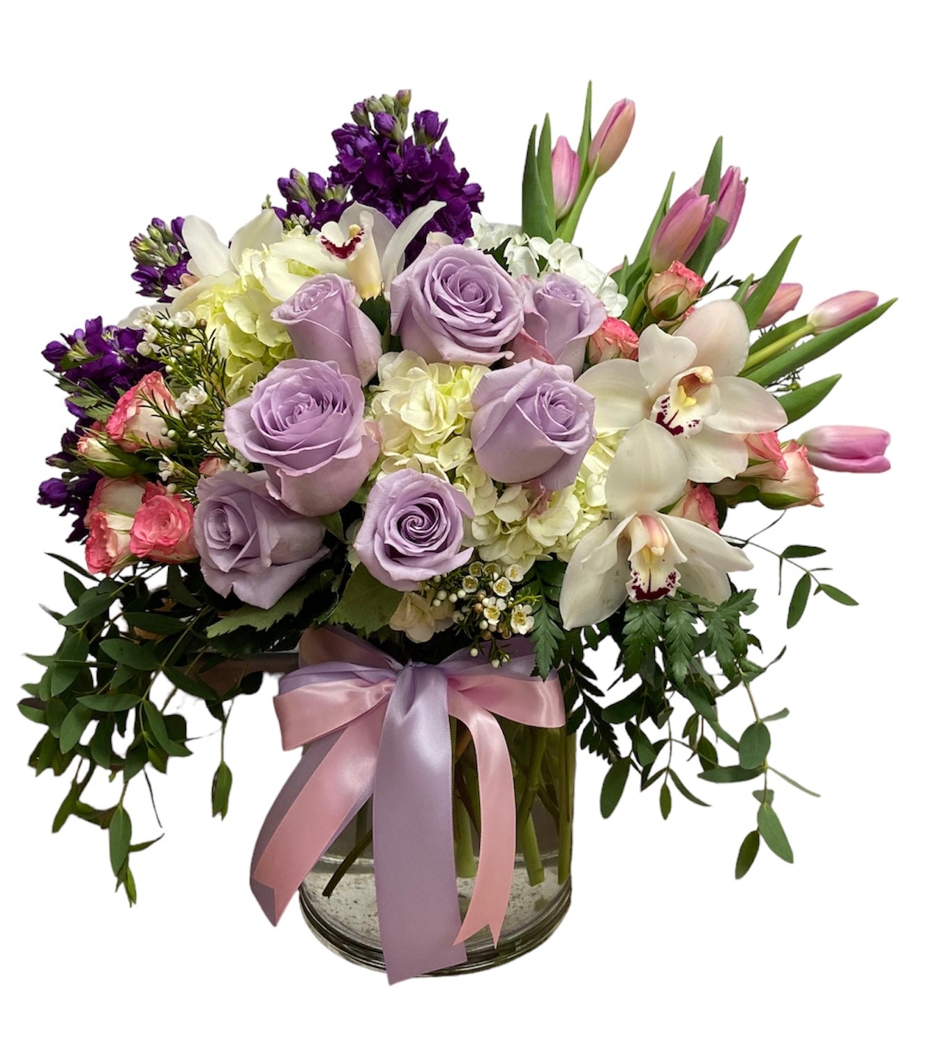 Bouquet of flowers with purple and white roses in a clear vase on a white background
