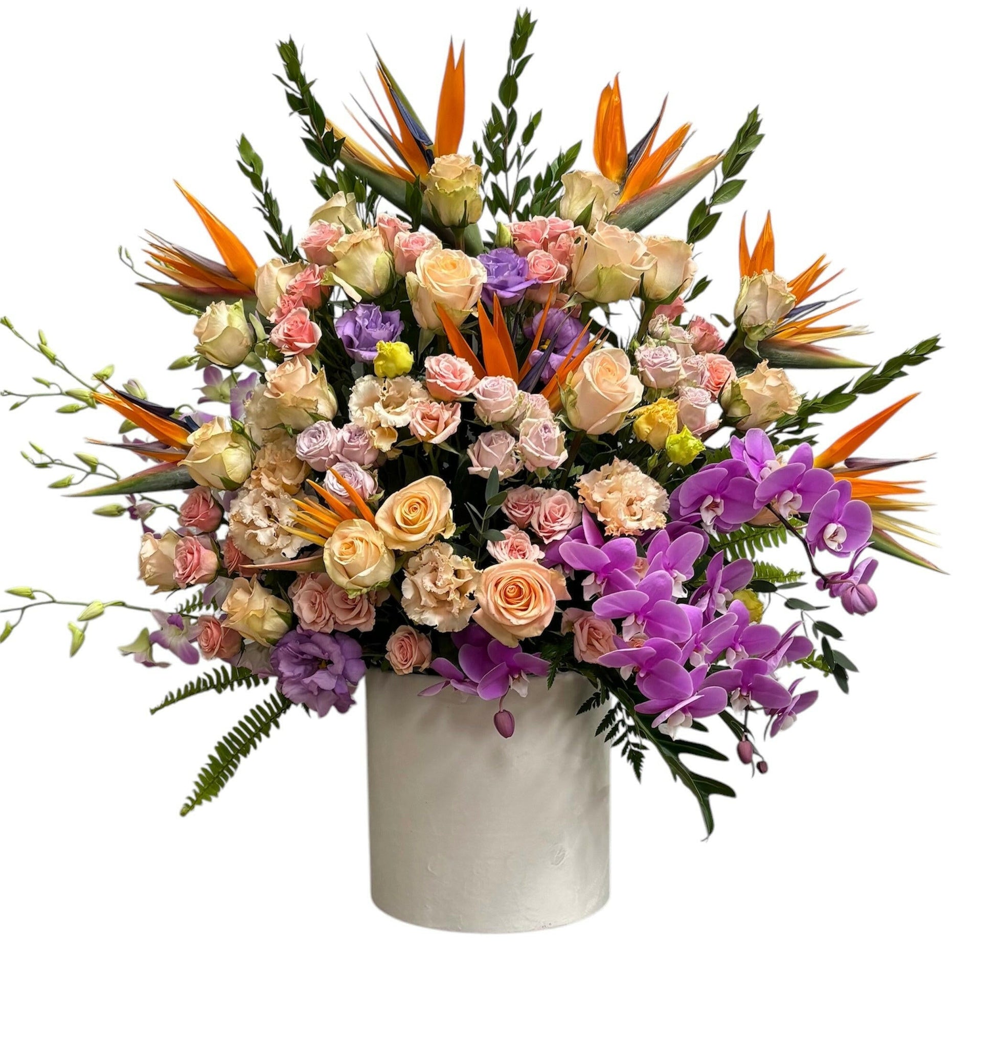 Bouquet of colorful flowers including roses and orchids in a white velvet vase on a white background