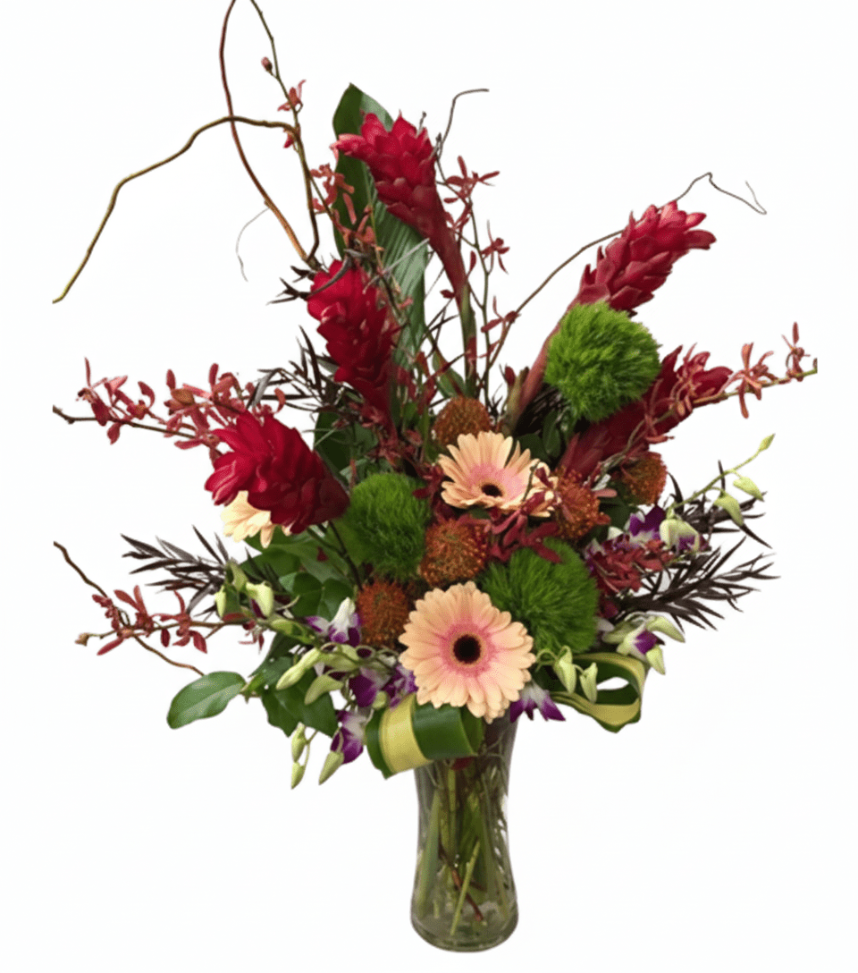 A vibrant, exotic floral arrangement in a clear glass vase against a solid white background. The bouquet features striking red ginger flowers, delicate peach-pink gerbera daisies, fluffy green textural elements, small reddish-brown orchids, and dark green foliage with some slender dried branches reaching upwards.